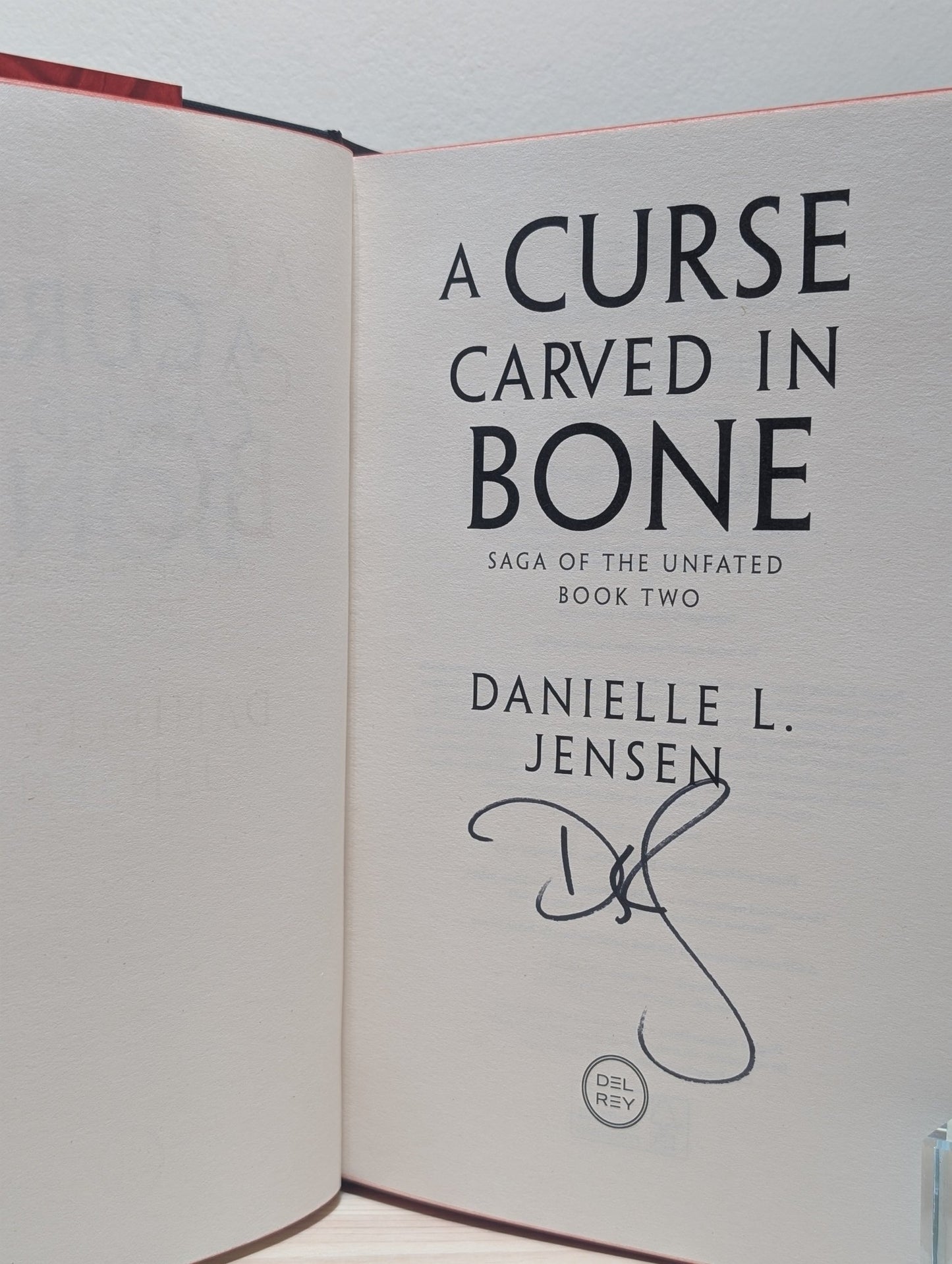 A Curse Carved in Bone by Danielle L. Jensen (Signed First Edition with sprayed edges) - Fialta Books