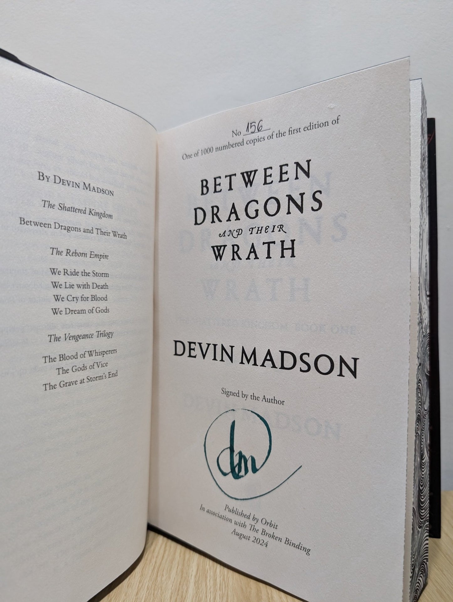 Between Dragons and Their Wrath by Devin Madson (Signed First Edition with sprayed edges) - Fialta Books