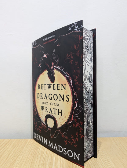 Between Dragons and Their Wrath by Devin Madson (Signed First Edition with sprayed edges) - Fialta Books